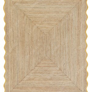 Puede incluir: Una alfombra de fibra natural con un patr&oacute;n geom&eacute;trico en tonos beige y marr&oacute;n. La alfombra tiene un borde festoneado con un borde amarillo.