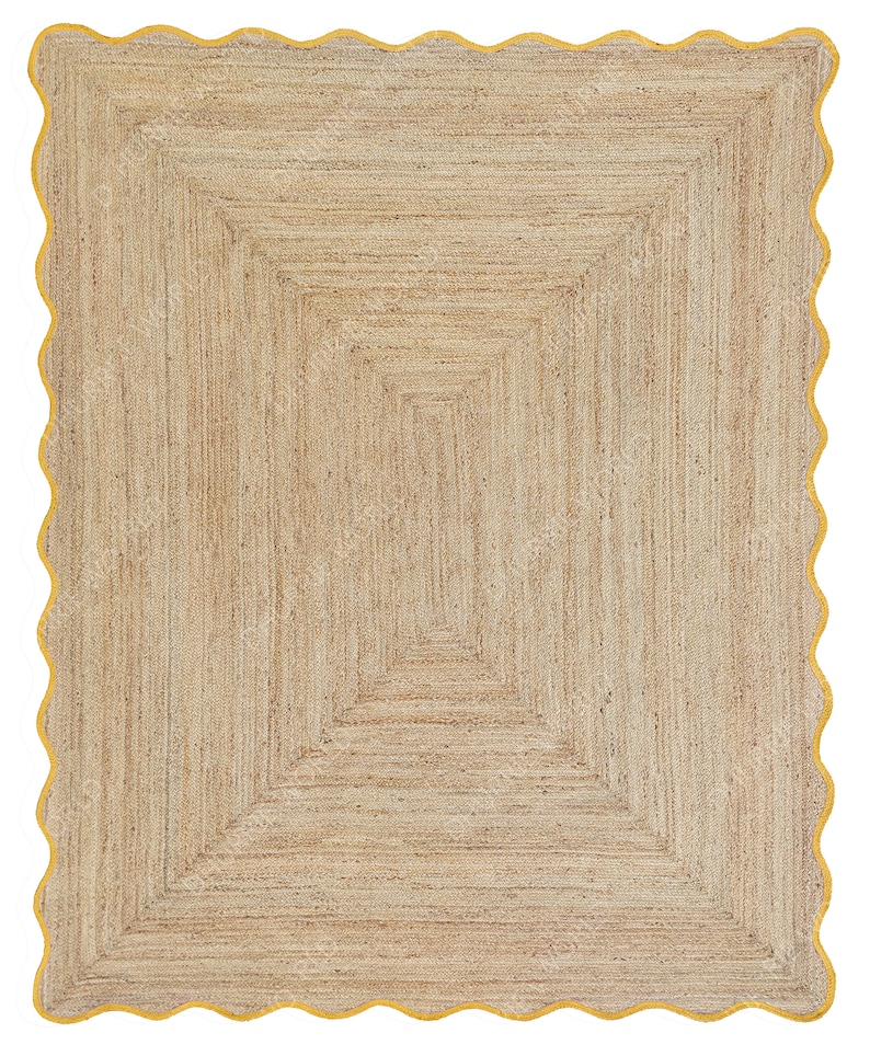 Puede incluir: Una alfombra de fibra natural con un patr&oacute;n geom&eacute;trico en tonos beige y marr&oacute;n. La alfombra tiene un borde festoneado con un borde amarillo.