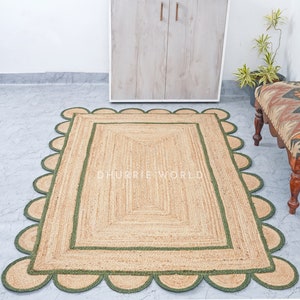 May include: A natural fiber rug with a green border and scalloped edges. The rug is made of jute and has a natural, earthy color. The rug is perfect for adding a touch of rustic charm to any room.