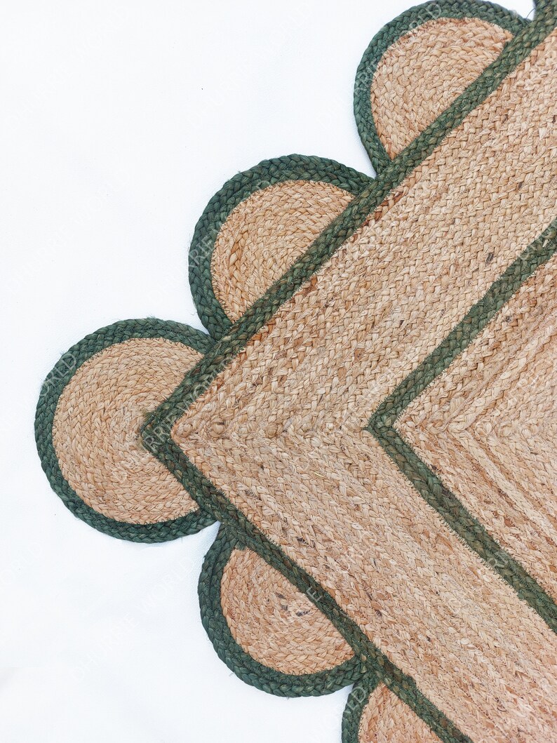 K&ouml;nnte beinhalten: Ein Jute-Teppich mit gr&uuml;nem Rand und gewellten Kanten. Der Teppich ist aus Naturfasern gefertigt und hat einen rustikalen Look.