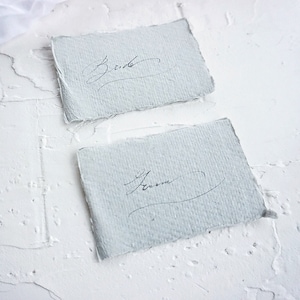 Colocar tarjetas de presentación para la recepción de bodas escritas a mano en caligrafía vintage sobre papel de trapo de algodón hecho a mano