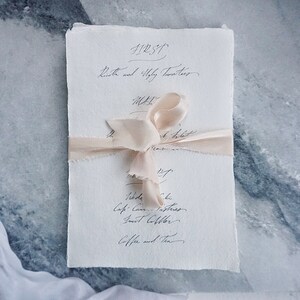 Tarjetas de menú escritas a mano en caligrafía en papel de trapo de algodón hecho a mano para recepción de bodas, cena formal, fiesta