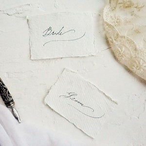 Colocar tarjetas de presentación para la recepción de bodas escritas a mano en caligrafía vintage sobre papel de trapo de algodón hecho a mano