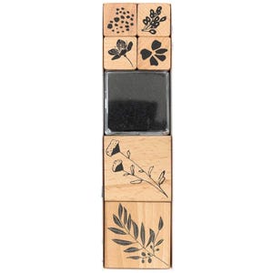 Könnte beinhalten: Ein Set Holzstempel mit floralen Designs, darunter Blumen und Blätter, und ein schwarzes Stempelkissen. Die Stempel sind in einer vertikalen Reihe angeordnet und zeigen verschiedene botanische Muster für Bastel- und Kunstprojekte.