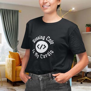 Könnte beinhalten: Schwarzes T-Shirt mit dem Text "Running Code Is My Cardio" in einem weißen, kreisförmigen Design. Das Shirt hat ein Codiermuster in der Mitte. Die Person trägt eine dunkle Jeans.