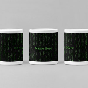 Puede incluir: Tres tazas de cerámica blanca con fondo negro y un patrón de código digital verde. Las tazas tienen el texto "Name Here" impreso en ellas.