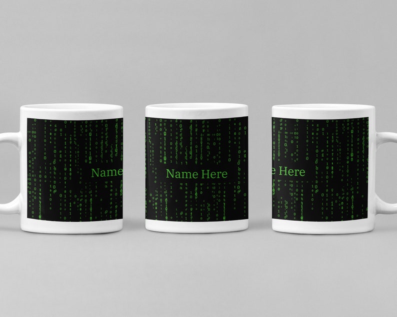 Może przedstawiać: Trzy białe ceramiczne kubki z czarnym tłem i zielonym wzorem kodu cyfrowego. Kubki mają nadrukowany tekst "Name Here".