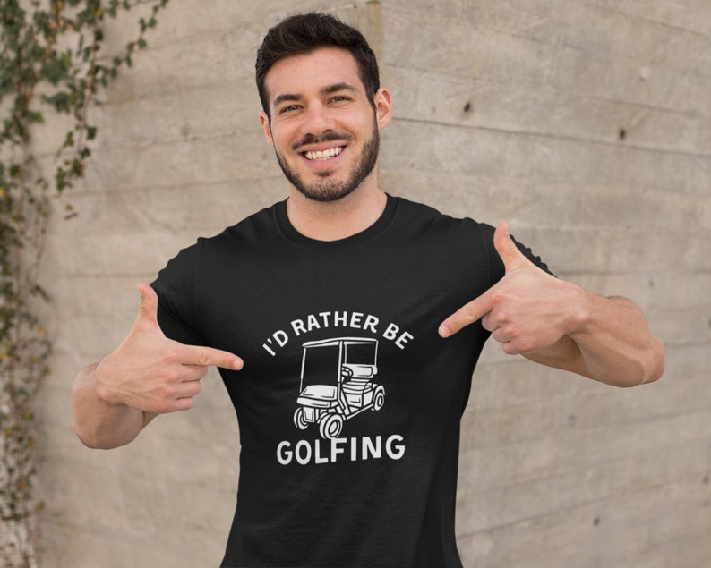 May include: Black t-shirt with white text that reads "I'd rather be golfing" and a white illustration of a golf cart.