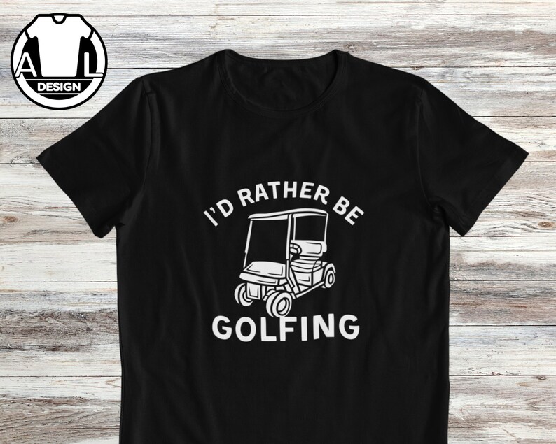 May include: Black t-shirt with white text that reads "I'd rather be golfing" and a white illustration of a golf cart.