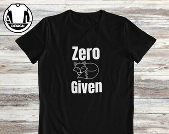 Op de afbeelding: Zwart T-shirt met witte tekst die "Zero Given" zegt en een slapende cartoonvos boven de tekst.