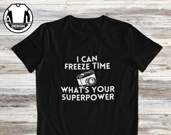 May include: Black t-shirt with white text that reads "I can freeze time. What's your superpower?" and a black and white camera graphic.