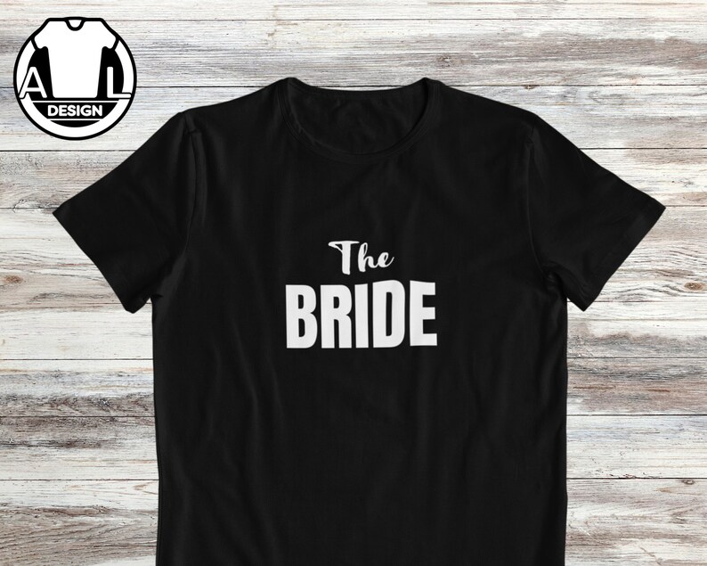 Pode incluir: Camiseta preta com texto branco que diz "The Bride".