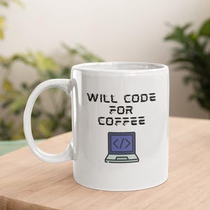 Könnte beinhalten: Weiße Keramik-Kaffeetasse mit dem Text "Will Code For Coffee" und einem blau-weißen Laptop-Symbol.