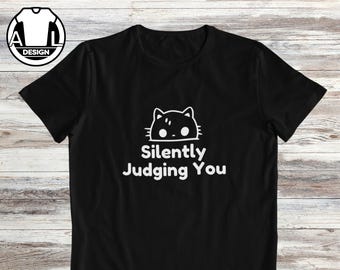 May include: Black t-shirt with a white graphic of a cat with the text "Silently Judging You".