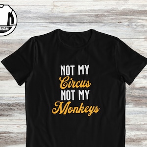 May include: Black t-shirt with the text "Not My Circus Not My Monkeys" in yellow.