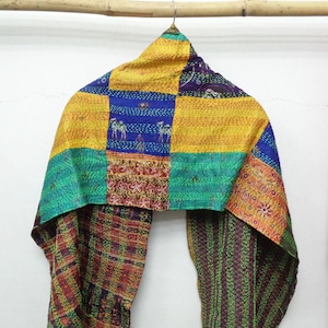 May include: A patchwork scarf with a variety of colors, including yellow, blue, green, and red. The scarf has a rectangular shape with a mix of patterned and solid fabric sections. The design includes embroidered details and animal motifs.
