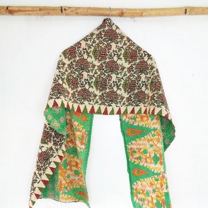 May include: A green and cream kantha scarf with a floral pattern. The scarf is made of recycled saris and is hand-stitched.