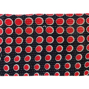 Puede incluir: Una tela negra con un patr&oacute;n de lunares rojos. La tela est&aacute; acolchada y tiene un hilo blanco que la atraviesa.