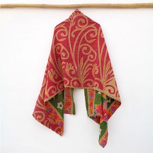 May include: A red and gold patterned scarf with a floral design. The scarf is hanging from a wooden rod. The reverse side of the scarf is green with floral and orange accents. The scarf is made of a soft, lightweight material.