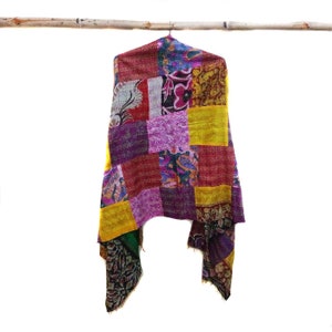 May include: A colorful patchwork quilt scarf with a variety of floral and geometric patterns in shades of yellow, red, purple, and green.