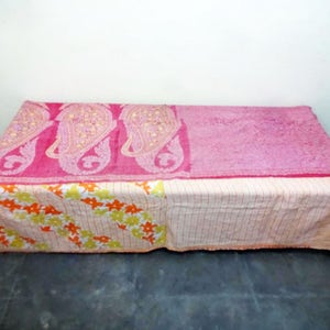 Puede incluir: Una colcha kantha rosa y blanca con un patr&oacute;n de paisley y dise&ntilde;o floral. La colcha est&aacute; hecha de saris reciclados y es perfecta para agregar un toque de estilo bohemio a tu hogar.