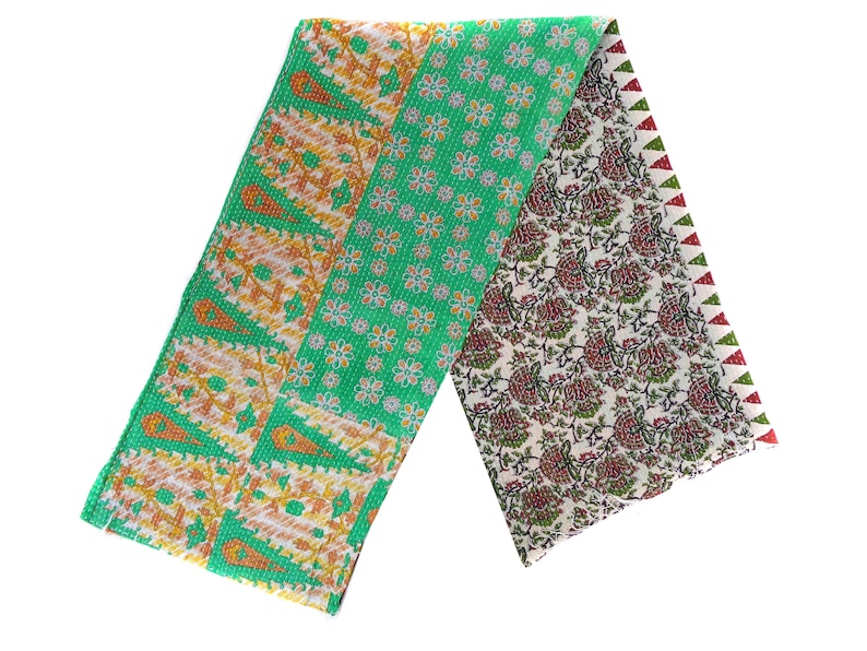 May include: A green, orange, and white kantha quilt with a floral pattern. The quilt is folded in half and has a red and green border.