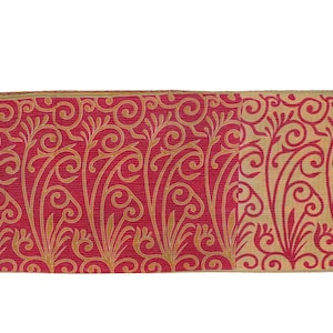 May include: A rectangular piece of fabric featuring a red backdrop with a gold, swirling floral design. The edges are trimmed with a thin gold border. The pattern is symmetrical and decorative.