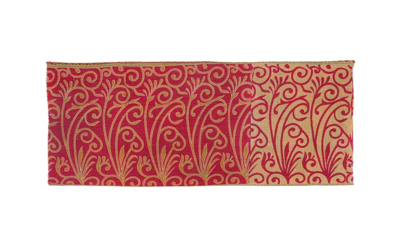May include: A rectangular piece of fabric featuring a red backdrop with a gold, swirling floral design. The edges are trimmed with a thin gold border. The pattern is symmetrical and decorative.