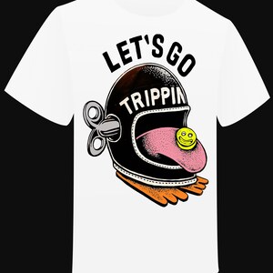 Peut inclure: T-shirt blanc avec un motif graphique représentant un casque noir avec l'inscription "LET'S GO TRIPPIN" et une langue rose avec un smiley jaune. Le motif comprend des pieds oranges et une clé à remonter.