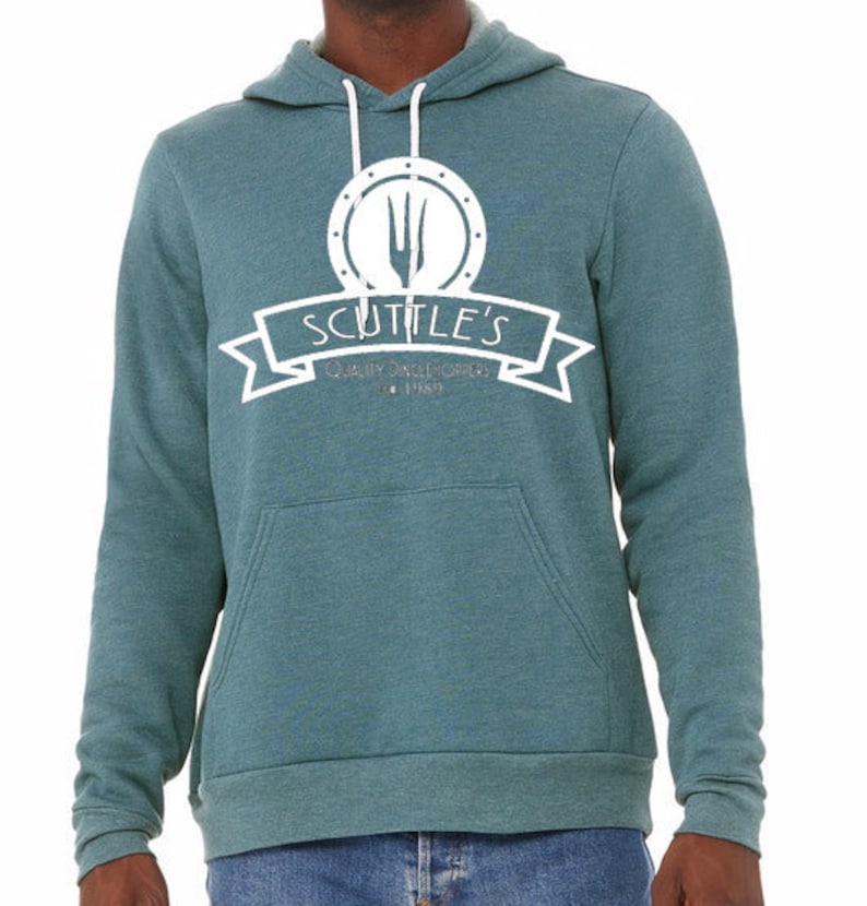 Puede incluir: Una sudadera con capucha azul turquesa con un logotipo blanco que dice "Scuttle's Quality Sandwiches Est. 1989". El logotipo presenta un tenedor y un cuchillo dentro de un c&iacute;rculo.