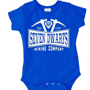 May include: A royal blue baby onesie with a white graphic of a diamond and two pickaxes. The text "Est. 1937 SEVEN DWARFS MINING COMPANY" is printed below the graphic.