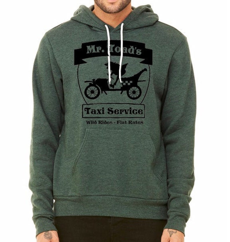 May include: A dark green hooded sweatshirt with a black graphic of a cartoon character driving a taxi. The graphic says "Mr. Toad's Taxi Service Wild Rides - Flat Rates".