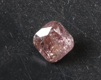 May include: A pink cushion-cut diamond gemstone with a faceted surface.