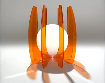 Może przedstawiać: Pomarańczowa lampa stołowa z akrylu z białym kloszem w kształcie kuli. Lampa ma geometryczny wzór z wieloma zakrzywionymi panelami.