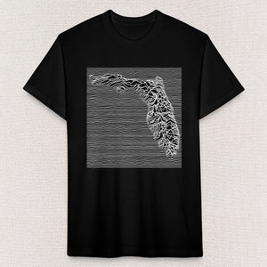 Puede incluir: Camiseta negra con un gráfico blanco del estado de Florida en un estilo pixelado.
