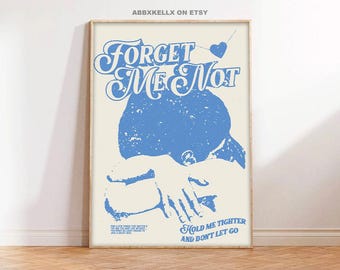 May include: Blue and white graphic print with the text "Forget Me Not" and "Hold Me Tighter and Don't Let Go". The graphic features a blue silhouette of a person with their arms wrapped around themselves.
