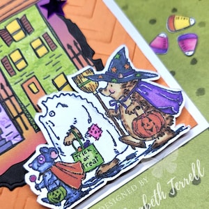 May include: A Halloween card featuring a white dog dressed as a ghost, a mouse dressed as a vampire, and a hedgehog dressed as a witch, all carrying trick-or-treat bags. The card is designed by Elizabeth Terrell.