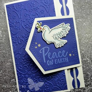May include: A blue and white Christmas card with a dove and the text "Peace on Earth".