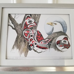 May include: Framed artwork featuring a Native American-inspired design with a red, black, and white bird perched on a tree branch. An eagle is depicted with a circular design. The artwork is in a silver frame.