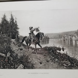 May include: A black and white print of a historical scene depicting a man on horseback blowing a trumpet. The man is wearing a feathered hat and a long coat. The horse is galloping towards a bridge and a town in the distance. The text "THE TRUMPETER OF HACKENBURG" is printed below the image.