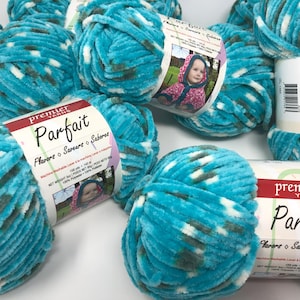 May include: Several skeins of Premier Parfait yarn in a vibrant turquoise color with white and gray accents. The yarn is soft and plush, perfect for knitting or crocheting projects. Each skein has a label with the brand name and a picture of a baby.