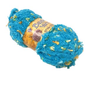 May include: A skein of bright turquoise textured yarn with flecks of yellow and green throughout. A tan paper label wraps around the center, featuring the text "Basic Yarn" and "37 Yds (33m)" along with a small graphic of a ball of yarn and needles.