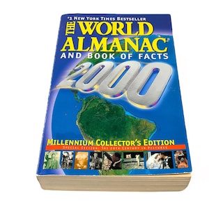 May include: The World Almanac and Book of Facts 2000, a Millennium Collector's Edition. The cover features a blue background with a world map and the number 2000 in silver. Includes a special section on the 20th century in pictures.