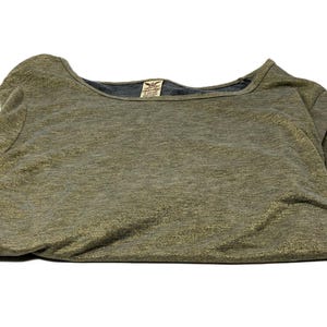 May include: Olive green long-sleeve shirt with a scoop neck and a dark gray neckline. The shirt has a textured appearance with gold flecks throughout. A small tag is visible near the neckline.