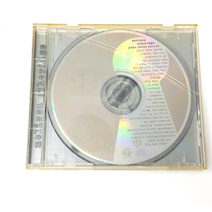 May include: A Melissa Etheridge Your Little Secret music CD in a clear plastic jewel case. The disc features a tracklist including I Really Like You and Nowhere to Go, with production credits for Hugh Padham and Island Records, dated 1995.
