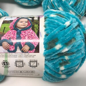 May include: A skein of bulky weight 5 yarn in a variegated turquoise, dark green, and white colorway. The paper label features a photograph of a child wearing a hooded jacket and includes technical knitting and crochet gauge information.