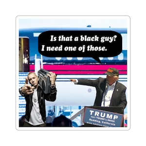 May include: A sticker featuring a humorous image of Eminem holding a boombox, with a speech bubble stating "Is that a black guy? I need one of those." Donald Trump is pointing at Eminem. The background includes a stage and the word "TRUMP".