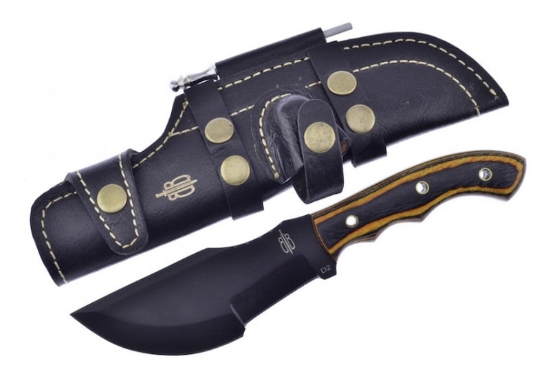 May include: A black fixed blade knife with a brown and black wood handle. The knife has a black leather sheath with a belt loop and a small pocket for a sharpening steel.