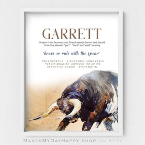 May include: A framed print featuring the name "GARRETT" in a brown font, with a watercolor illustration of a bull. The text describes the name's origins and meaning, along with associated traits like "trustworthy" and "righteous".