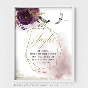 May include: A printable art print with a gold geometric frame and the name "Jaylee" in a script font. The background is a watercolor wash of pink and purple with gold glitter. The quote "Be faithful, even to the point of death, and I will give you life as your victor's crown. Revelation 2:10" is printed below the name.